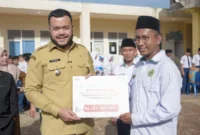 Wali Kota Padang Fadly Amran menyerahkan bantuan operasional dari PT Semen Padang untuk MTsS Luki, Senin (15/9/2025). (Foto: Prokopim Padang)