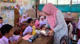 Ketua TP-PKK Ny. Sifrowati Yulianto membagikan makanan bergizi kepada siswa SDN 05 Pasaman. (Foto: Diskominfo Pasbar)