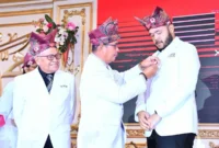 Ketua PMI Padang, Zulhardi Z. Latif menyematkan Lencana Jasa Pratama kepada Wali Kota Padang Fadly Amran pada Puncak Peringatan HUT ke-80 PMI di Auditorium Universitas Baiturrahmah, Rabu (17/9/2025). (Foto: Prokopim Padang)