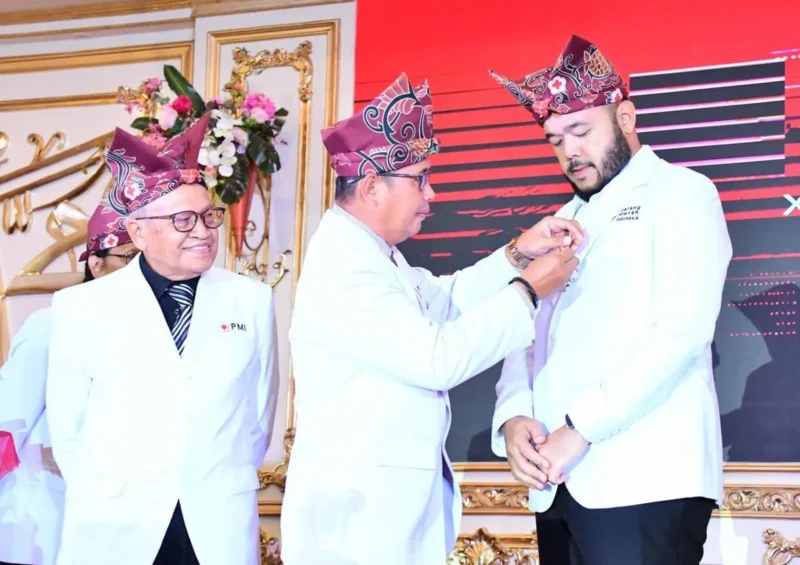 Ketua PMI Padang, Zulhardi Z. Latif menyematkan Lencana Jasa Pratama kepada Wali Kota Padang Fadly Amran pada Puncak Peringatan HUT ke-80 PMI di Auditorium Universitas Baiturrahmah, Rabu (17/9/2025). (Foto: Prokopim Padang)