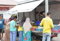 Sejumlah warga membeli kebutuhan pokok di pasar murah yang dipusatkan di depan Masjid Raya Ganting. (Foto: FB Diskominfo Padang)