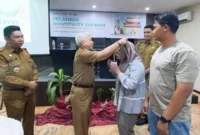 Staf Ahli Wali Kota Padang Bidang SDM dan Kemasyarakatan, Syahrial Kamat memasangkan kokarde kepada peserta Pelatihan Hospitality Tourism, Selasa (19/8/2025). (Foto: FB Diskominfo Padang)