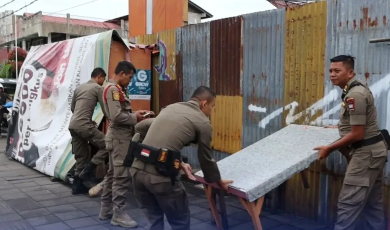 Petugas Satpol PP Padang menertibkan lapak PKL di atas trotoar, Selasa (16/9/2025) pagi. (Foto: Humas Satpol PP Padang)