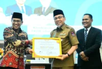 Wakil Wali Kota Padang, Maigus Nasir menerima penghargaan dari Kepala Pusat Kerukunan Umat Beragama Kemenag RI, Adib Abdushomad. (Foto: Prokopim Padang)
