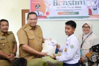 Wali Kota Pariaman Yota Balad menyerahkan bantuan beras kepada anak yatim di Aula Kantor Camat Pariaman Timur, Senin (6/10/2025). (Foto: Kominfo Pariaman)