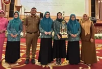 
Ketua TP PKK Kecamatan Basa Ampek Balai Tapan, dr Elsa M Pohan (pegang piala) dan Ketua TP-PKK Pessel, Ny Lisda Hendrajoni (tengah) foto bersama usai menerima penghargaan. (Foto: Dok. Samwil)