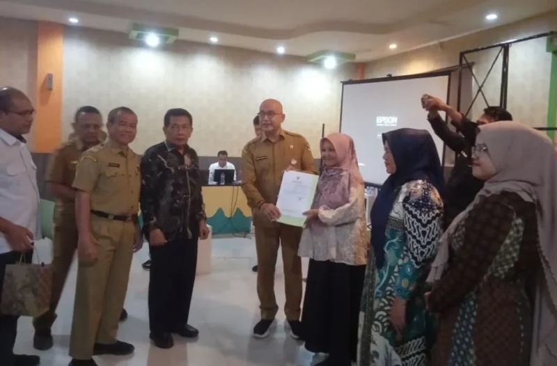 Kepala DPMPTSP Sumbar, Luhur Budianda didampingi Anggota DPRD Sumbar, Bakri Bakar menyerahkan NIB kepada salah satu pelaku usaha. (Foto: Dok. Yoniks)