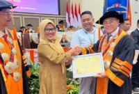 Kepala Bidang Statistik Persandian Diskominfo Padang, Devi Susanti Razif menerima penghargaan dari Direktur PNP, Surfa Yondri, Senin (6/10/2025). (Foto: FB Diskominfo Padang)
