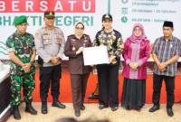 Bupati Dharmasraya Annisa Suci Ramadhani menyerahkan piagam penghargaan kepada Kajari Dharmasraya atas suksesnya kegiatan Dharmasraya Bersatu Bhakti Negeri. (Foto: Kominfo Dharmasraya)