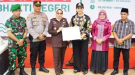 Bupati Dharmasraya Annisa Suci Ramadhani menyerahkan piagam penghargaan kepada Kajari Dharmasraya atas suksesnya kegiatan Dharmasraya Bersatu Bhakti Negeri. (Foto: Kominfo Dharmasraya)