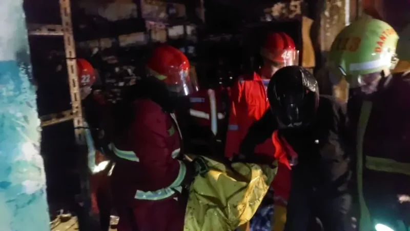 Personel Damkar mengevakuasi jasad korban dari dalam ruko di Belakang Lintas, Kelurahan Olo, Kecamatan Padang Barat, Jumat (24/10/2025). (Foto: Dinas Damkar Padang)