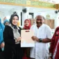 Ketua TP-PKK Kota Padang, Ny. dr. Dian Puspita Fadly Amran, Sp.Jp menyerahkan bantuan kepada korban kebakaran Pasar Gadang, Kamis (16/10/2025). (Foto: Prokopim Padang)
