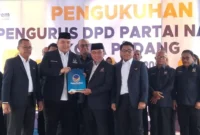 Sekretaris DPW Partai NasDem Sumbar Nanda Satria menyerahkan SK kepada Ketua DPD Partai NasDem Padang Maigus Nasir saat pengukuhan di NasDem Tower, Minggu (19/10). (Foto: Ist)