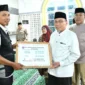 Wakil Wali Kota Padang, Maigus Nasir, menyerahkan secara simbolis dana operasional triwulan III bagi Ketua RT/RW dan lainnya se-Kecamatan Kuranji di Masjid Jami’atul Huda, Jalan By Pass Ketaping, Rabu (29/10/2025). (Foto: Prokopim Padang)