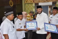 Wali Kota Padang Fadly Amran secara simbolis menyerahkan dana operasional RT/RW Padang Timur Triwulan III di Masjid Raya Andalas, Rabu (22/10/2025). (Foto: Prokopim Padang)