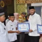 Wali Kota Padang Fadly Amran secara simbolis menyerahkan dana operasional RT/RW Padang Timur Triwulan III di Masjid Raya Andalas, Rabu (22/10/2025). (Foto: Prokopim Padang)
