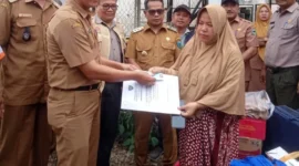 Kepala Dinas Dukcapil Pessel, Beriskhan disaksikan Wabup Pessel, Risnaldi Ibrahim menyerahkan dokumen kependudukan kepada korban kebakaran di Nagari Koto VIII Palangai. (Foto: Dok. Yoniks)