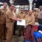 Kepala Dinas Dukcapil Pessel, Beriskhan disaksikan Wabup Pessel, Risnaldi Ibrahim menyerahkan dokumen kependudukan kepada korban kebakaran di Nagari Koto VIII Palangai. (Foto: Dok. Yoniks)
