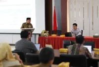 Wakil Wali Kota Padang, Maigus Nasir memberikan sambutan pada Rapat Evaluasi bersama Tim Satgas Percepatan Program Jamkesmas 2025 di Aula Kantor Dinas Kesehatan Padang, Selasa (21/10/2025). (Foto: Prokopim Padang)