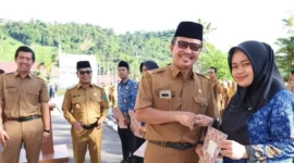 Pj Sekdakab Pessel, Evafauza Yuliasman SE, M.Si disaksikan Wabup Pessel, Risnaldi Ibrahim dan Kepala BKPSDM menyerahkan SK kepada salah satu PPPK saat pelantikan. (Foto: Dok. Prokopim)
