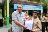 Wali Kota Pariaman Yota Balad secara simbolis menyerahkan seragam sekolah gratis kepada siswa keluarga kurang mampu di SMP se-Kota Pariaman, Kamis (16/10/2025).
