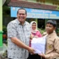 Wali Kota Pariaman Yota Balad secara simbolis menyerahkan seragam sekolah gratis kepada siswa keluarga kurang mampu di SMP se-Kota Pariaman, Kamis (16/10/2025).