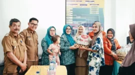 Ketua TP-PKK sekaligus Ketua TP Posyandu Kabupaten Solsel, Ny. Hj. Erniati Khairunas menyerahkan bantuan kepada warga. (Foto: Humas Pemkab Solsel)