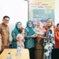 Ketua TP-PKK sekaligus Ketua TP Posyandu Kabupaten Solsel, Ny. Hj. Erniati Khairunas menyerahkan bantuan kepada warga. (Foto: Humas Pemkab Solsel)