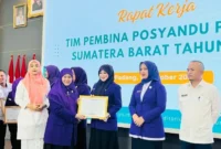 Ketua TP Posyandu Pesisir Selatan, Ny Lisda Hendrajoni saat menerima penghargaan dari ketua TP Posyandu Sumbar, Ny Harneli Mahyeldi. (Foto: Dok. Prokopim)