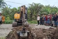 Operator alat berat melakukan penggalian parit di badan jalan untuk memblokir akses kendaraan menuju perusahaan. (Foto: Dok. OKM)