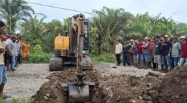 Operator alat berat melakukan penggalian parit di badan jalan untuk memblokir akses kendaraan menuju perusahaan. (Foto: Dok. OKM)