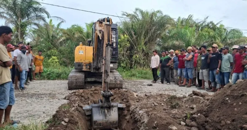 Operator alat berat melakukan penggalian parit di badan jalan untuk memblokir akses kendaraan menuju perusahaan. (Foto: Dok. OKM)