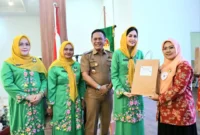 Ketua DWP Kota Padang, Ny. Vanny Andree Algamar secara simbolis menyerahkan peralatan workshop kepada peserta, Selasa (7/10/2025). (Foto: Prokopim Padang)