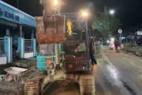 Pemko Padang membersihkan akses jalan Pasar Baru–Unand yang sempat tertutup lumpur akibat banjir bandang, Jumat (28/11/2025) malam. (Foto: Prokopim Padang)