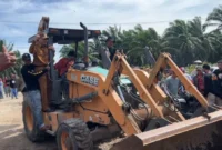 Bupati Pessel Hendrajoni menaiki ekskavator saat pembukaan akses jalan menuju PT Incasi Raya.