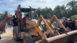 Bupati Pessel Hendrajoni menaiki ekskavator saat pembukaan akses jalan menuju PT Incasi Raya.