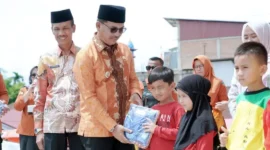 Bupati Solsel H. Khairunas didampingi Wakil Bupati H. Yulian Efi membagikan bantuan seragam gratis kepada siswa di RTH Padang Aro, Kamis (6/2025). (Foto: Humas Solsel)