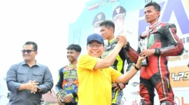 Wakil Wali Kota Padang, Maigus Nasir menyerahkan piala kepada pemenang FAM Road Race Championship, Minggu (16/11/2025). (Foto: Prokopim Padang)