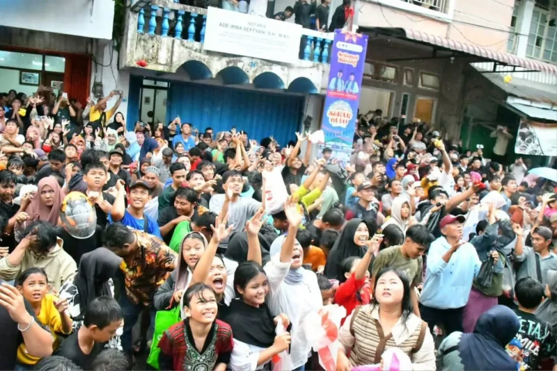 Hujan deras yang mengguyur Kota Padang tidak menyurutkan semangat masyarakat untuk mengikuti Tradisi Serak Gulo di depan Masjid Muhammadan,  Sabtu (22/11/2025) sore. (Foto: Prokopim Padang)
