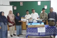 Kepala Dinas Sosial PPKBPPPA Padang Panjang Winarno menyalurkan bantuan kepada 18 KPM yang melaksanakan Graduasi Mandiri PKH 2025 di Aula Dinas Sosial PPKBPPPA, Jumat (21/11/2025). (Foto: Kominfo Padang Panjang)