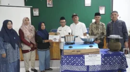 Kepala Dinas Sosial PPKBPPPA Padang Panjang Winarno menyalurkan bantuan kepada 18 KPM yang melaksanakan Graduasi Mandiri PKH 2025 di Aula Dinas Sosial PPKBPPPA, Jumat (21/11/2025). (Foto: Kominfo Padang Panjang)