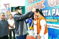 Wali Kota Padang Fadly Amran mengalungkan medali kepada salah satu juara Karate Open Piala Wali Kota Padang 2025, Minggu (16/11/2025). (Foto: Prokopim Padang)