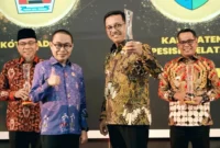 Bupati Solok Selatan, H. Khairunas menerima penghargaan dari Komisi Informasi Sumbar dalam acara Anugerah Keterbukaan Informasi Publik di Auditorium Gubernur Sumatera Barat, Selasa (18/11/2025). (Foto: Humas Pemkab Solsel)