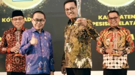 Bupati Solok Selatan, H. Khairunas menerima penghargaan dari Komisi Informasi Sumbar dalam acara Anugerah Keterbukaan Informasi Publik di Auditorium Gubernur Sumatera Barat, Selasa (18/11/2025). (Foto: Humas Pemkab Solsel)