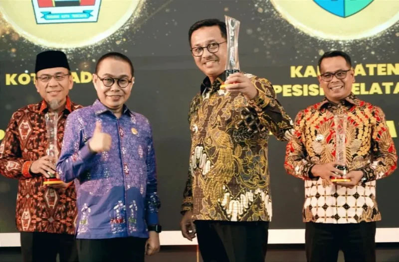 Bupati Solok Selatan, H. Khairunas menerima penghargaan dari Komisi Informasi Sumbar dalam acara Anugerah Keterbukaan Informasi Publik di Auditorium Gubernur Sumatera Barat, Selasa (18/11/2025). (Foto: Humas Pemkab Solsel)