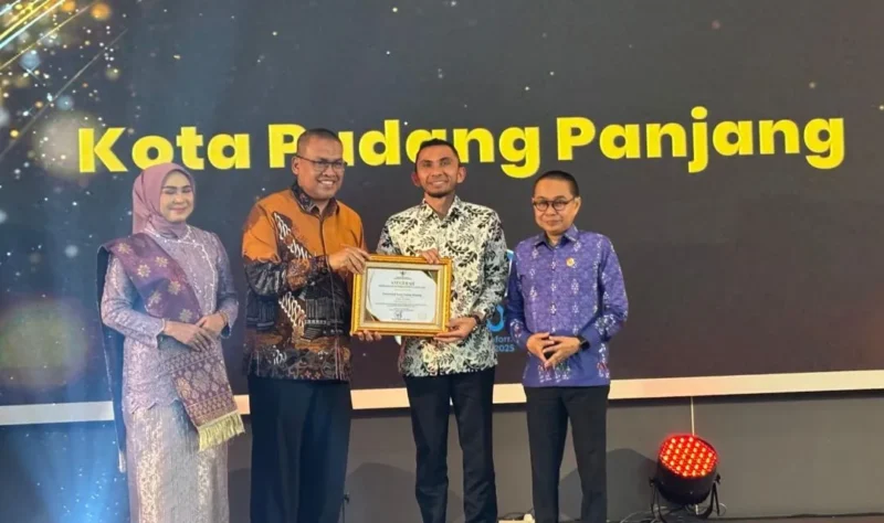 Sekdaprov Sumbar, Arry Yuswandi didampingi Ketua KI Sumbar, Musfi Yendra dan anggota Mona Sisca menyerahkan penghargaan kepada Wakil Wali Kota Padang Panjang, Allex Saputra, Selasa (18/11/2025) malam. (Foto: Kominfo Padang Panjang)