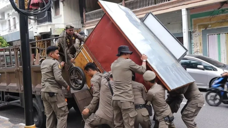 Petugas Satpol PP Kota Padang menertibkan lapak PKL yang melanggar aturan, Jumat (14/11/2025). (Foto: Humas Satpol PP Padang)