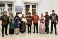 Wakil Wali Kota Padang Maigus Nasir bersama Kepala Diskominfo Padang Boby Firman dan jajaran usai menerima penghargaan KIP Sumbar 2025 di Auditorium Gubernur Sumbar, Selasa (18/11/2025) malam. (Foto: Diskominfo Padang)