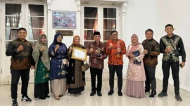 Wakil Wali Kota Padang Maigus Nasir bersama Kepala Diskominfo Padang Boby Firman dan jajaran usai menerima penghargaan KIP Sumbar 2025 di Auditorium Gubernur Sumbar, Selasa (18/11/2025) malam. (Foto: Diskominfo Padang)