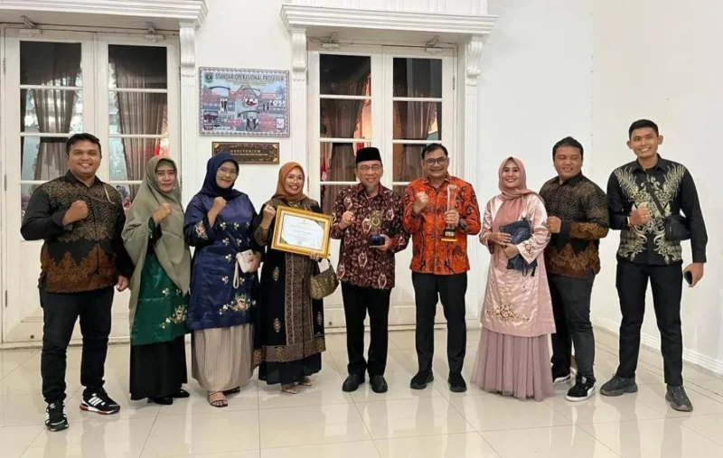 Wakil Wali Kota Padang Maigus Nasir bersama Kepala Diskominfo Padang Boby Firman dan jajaran usai menerima penghargaan KIP Sumbar 2025 di Auditorium Gubernur Sumbar, Selasa (18/11/2025) malam. (Foto: Diskominfo Padang)